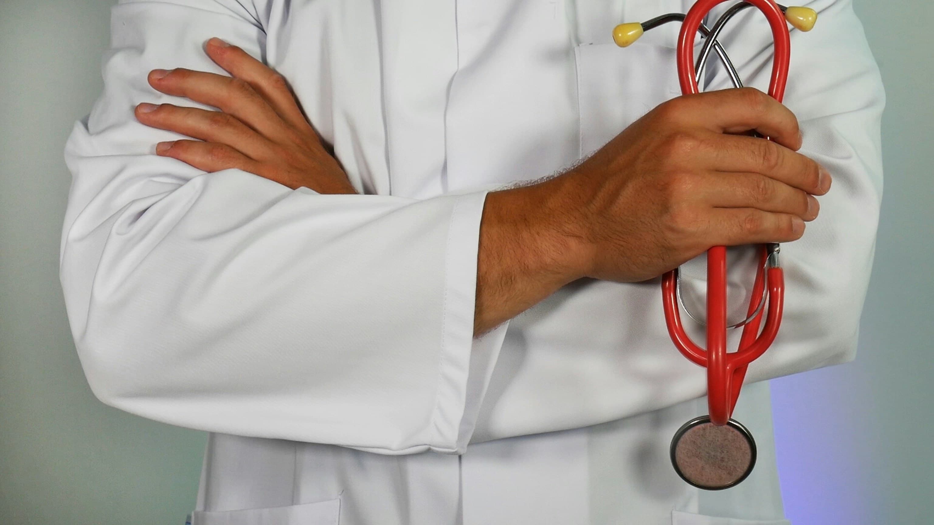Médico de jaleco segurando estetoscópio